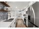 Well-lit kitchen boasts white cabinetry, stainless steel appliances, and stylish black and white backsplash at 1324 Pasadena S Ave # 204, South Pasadena, FL 33707
