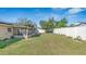 Backyard with spacious lawn, perimeter fence, and covered patio at 13826 Pathfinder Dr, Tampa, FL 33625