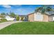 Charming home featuring a well-manicured lawn, solar panels, desert landscaping, and a welcoming entrance at 13826 Pathfinder Dr, Tampa, FL 33625