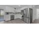 Modern kitchen with white cabinets, stainless steel appliances, and stylish tile backsplash at 13826 Pathfinder Dr, Tampa, FL 33625