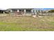 Spacious backyard features a fenced-in yard, patio with dining furniture, and lovely landscaping at 1518 New Bedford Dr, Sun City Center, FL 33573