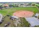 Aerial shot featuring baseball field with players, golf carts, and views of the surrounding neighborhood at 1518 New Bedford Dr, Sun City Center, FL 33573
