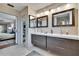 Bathroom featuring double vanity with sleek mirrors, vanity lighting and tile flooring at 1518 New Bedford Dr, Sun City Center, FL 33573