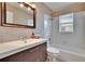 Bathroom featuring a modern sink and vanity, tiled walls, and shower with tub combination at 1518 New Bedford Dr, Sun City Center, FL 33573