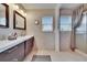 Bathroom featuring double sinks with modern vanity, neutral tile, and a glass door shower at 1518 New Bedford Dr, Sun City Center, FL 33573