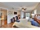 Bright bedroom with wood floors, ceiling fan, entertainment center, and sliding glass doors to the patio at 1518 New Bedford Dr, Sun City Center, FL 33573