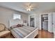 Cozy bedroom featuring a queen bed with a plaid cover, a window, and and closets at 1518 New Bedford Dr, Sun City Center, FL 33573