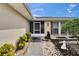 Charming home entrance with a brick walkway, rock garden, and a screened-in porch under a clear blue sky at 1518 New Bedford Dr, Sun City Center, FL 33573