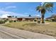 Attractive single-story home with a well-manicured lawn and a mature palm tree in a desirable neighborhood at 1518 New Bedford Dr, Sun City Center, FL 33573