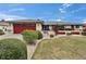 Charming home with a red garage door, landscaped yard, and vibrant flowerbeds enhancing its curb appeal at 1518 New Bedford Dr, Sun City Center, FL 33573
