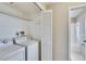 Functional laundry room with a washer, dryer, shelving, and access to the bathroom with a shower and tub at 1518 New Bedford Dr, Sun City Center, FL 33573