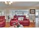 Comfortable living room featuring plush red reclining sofas, stylish lamps, and a view of the scenic outdoors at 1518 New Bedford Dr, Sun City Center, FL 33573