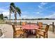 Outdoor patio area overlooking the water and featuring a rustic wooden table with chairs at 1518 New Bedford Dr, Sun City Center, FL 33573