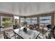 Enclosed sunroom with panoramic views of the lake, a tile floor, and multiple seating options at 1518 New Bedford Dr, Sun City Center, FL 33573