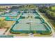 Aerial view of the community's multiple well-maintained tennis courts surrounded by lush landscaping at 1518 New Bedford Dr, Sun City Center, FL 33573