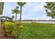 Expansive backyard featuring lush lawn, mature trees, and tranquil pond views at 17541 Corkwood Bend Trl, Punta Gorda, FL 33982