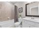 Bathroom features a shower-tub combo, white vanity, framed mirror, tile flooring, and neutral walls at 17541 Corkwood Bend Trl, Punta Gorda, FL 33982