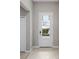 Entryway with neutral walls, tile flooring, a white front door with glass panels, and a closet at 17541 Corkwood Bend Trl, Punta Gorda, FL 33982