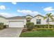 Charming single-story home with a manicured lawn, palm tree, and paved driveway at 17541 Corkwood Bend Trl, Punta Gorda, FL 33982