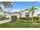 Traditional home with a two-car garage, paver driveway, and manicured lawn and landscaping at 17541 Corkwood Bend Trl, Punta Gorda, FL 33982