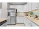Bright kitchen features white cabinets, granite countertops and stainless steel appliances at 17541 Corkwood Bend Trl, Punta Gorda, FL 33982