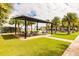 Inviting outdoor seating area with tables and chairs surrounded by lush landscaping and palm trees at 17541 Corkwood Bend Trl, Punta Gorda, FL 33982
