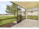 Covered and screened patio with brick floor overlooking the grassy backyard and community lake at 17541 Corkwood Bend Trl, Punta Gorda, FL 33982