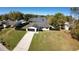 Aerial view of home with a fenced yard, long driveway, and close proximity to a serene lake at 18614 San Rio Cir, Lutz, FL 33549