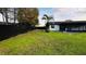Wide backyard features lush green lawn and black fence, providing ample space for outdoor activities at 18614 San Rio Cir, Lutz, FL 33549
