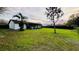 Expansive backyard with a covered patio, lush greenery, and a dark privacy fence at 18614 San Rio Cir, Lutz, FL 33549