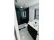 Modern bathroom featuring sleek black accents, a glass-enclosed shower, and a stylish, illuminated mirror at 18614 San Rio Cir, Lutz, FL 33549