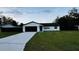 Attractive single-story home boasting a lush green lawn and a practical two-car garage at 18614 San Rio Cir, Lutz, FL 33549