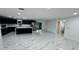 Modern kitchen featuring black cabinetry, island, and stainless steel appliances over glossy white marble flooring at 18614 San Rio Cir, Lutz, FL 33549