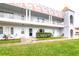 Three story condo building featuring white siding and a unique architectural design with a grassy lawn in front at 2100 World Parkway Blvd # 30, Clearwater, FL 33763