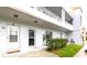 Two story condo building featuring white siding and a grassy lawn with unit entrances at 2100 World Parkway Blvd # 30, Clearwater, FL 33763