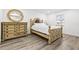 Bedroom featuring light wood floors, a round mirror, and a wooden bed frame at 2101 Cordova Grn, Seminole, FL 33777