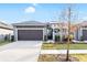 Charming home featuring a two-car garage, landscaped yard, and an inviting entryway at 219 Villa Luna Ln, Lutz, FL 33549
