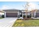 Charming home featuring a two-car garage, landscaped yard, and an inviting entryway at 219 Villa Luna Ln, Lutz, FL 33549