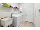 Bright laundry room with modern appliances, a sink and storage shelving at 219 Villa Luna Ln, Lutz, FL 33549