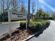 Entrance to Woodlake Run featuring an attractive community sign amidst lush landscaping at 233 Woodlake Wynde, Oldsmar, FL 34677