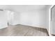 Bright living room features light gray hardwood floors, white walls, and natural light from large windows at 2535 E Stanley Matthew Cir, Tampa, FL 33604