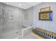 Contemporary bathroom features a frameless glass shower, modern bench, and beautiful wall art at 301 1St S St # 3103, St Petersburg, FL 33701