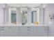 Sleek bathroom showcasing a double vanity with white countertop, backlit mirrors and decorative accessories at 301 1St S St # 3103, St Petersburg, FL 33701