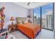 Bright bedroom with a large window offering city views, an orange comforter, and unique design at 301 1St S St # 3103, St Petersburg, FL 33701