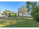 Spacious backyard with a well-maintained lawn, wooden deck, privacy fence, and storage shed at 304 David Ave, Clearwater, FL 33759