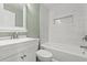 Well-lit bathroom features a bathtub with tiled walls, a toilet and a modern vanity with a sink at 304 David Ave, Clearwater, FL 33759