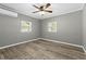 Comfortable bedroom with wood-look flooring, two windows and a ceiling fan at 304 David Ave, Clearwater, FL 33759