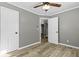 Cozy bedroom with wood-look flooring, ceiling fan and a view into the bathroom at 304 David Ave, Clearwater, FL 33759