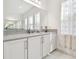Bright bathroom vanity with white cabinets, grey countertops and large mirror at 3280 Juniper Springs St, Wesley Chapel, FL 33543