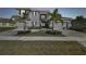 Elegant two-story home boasts a three-car garage and meticulous landscaping with lush palm trees at dusk at 3280 Juniper Springs St, Wesley Chapel, FL 33543